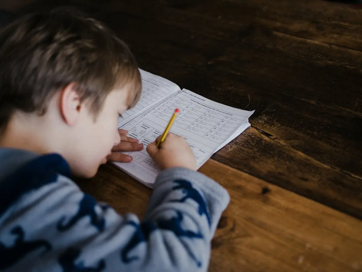 A young student working on a school worksheet